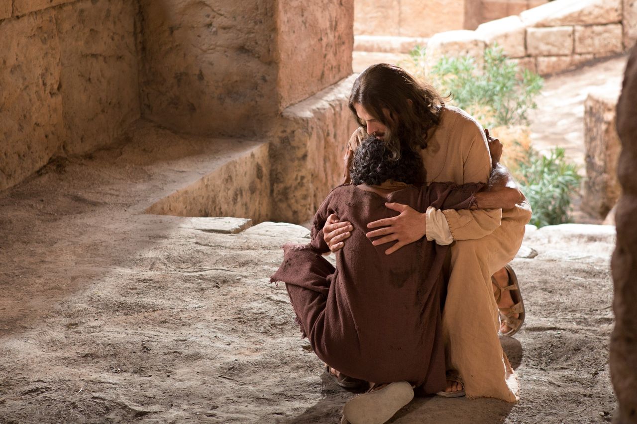 Jesus umarmt einen Mann am Boden