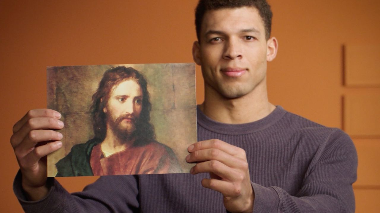 Ein Mann hält ein Bild von Jesus Christus hoch