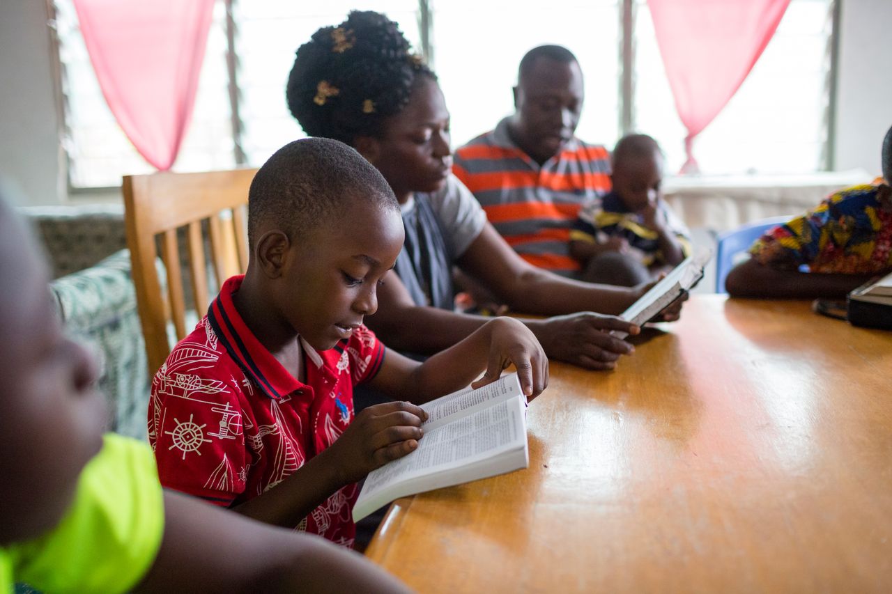 Ein Vater liest mit seinen Kindern in der Bibel