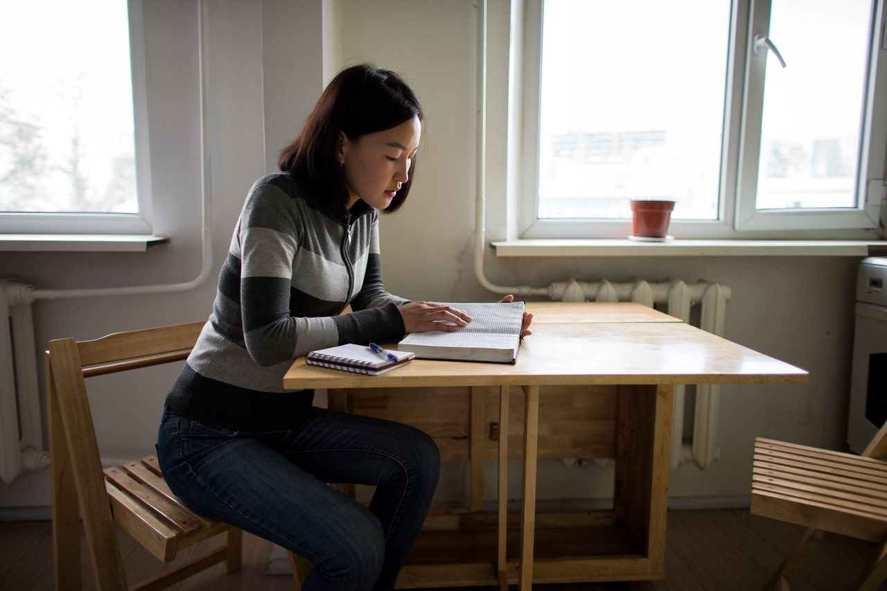 Eine Frau liest am Küchentisch im Buch Mormon