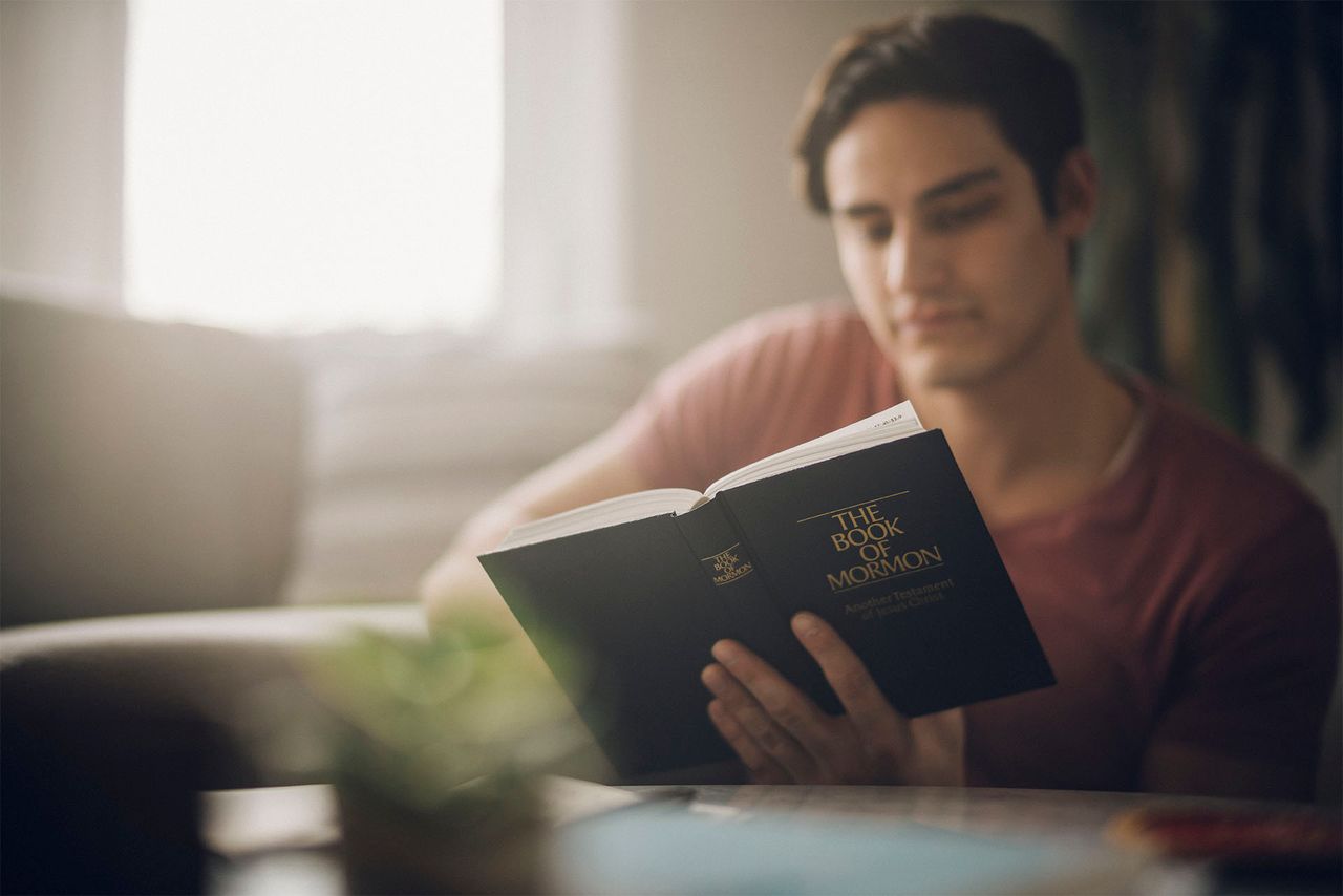 Ein Mann liest am Küchentisch im Buch Mormon